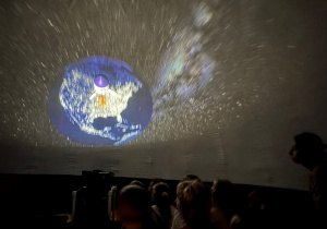 Dzieci siedzą wewnątrz balonowego planetarium
