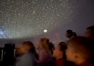 Dzieci siedzą wewnątrz balonowego planetarium