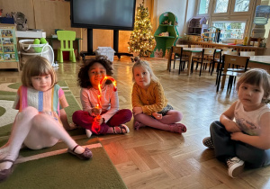 Dziewczynka trzyma świecącą laskę świąteczną