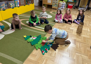 Chłopiec przyczepia ozdoby do filcowej choinki