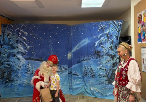 Chłopiec pozuje do zdjęcia ze Świętym Mikołajem