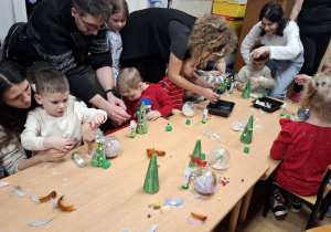 Dzieci podczas przygotowywania ozdób świątecznych z rodzicami