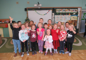 Świętujemy urodziny dziewczynki, dzieci stoją wokół dziewczynki, która ma na głowie koronę.