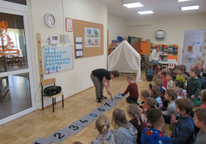 Chłopiec układa kwadraty z liczbami.