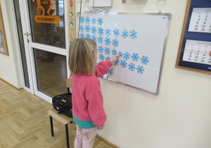 Dziewczynka przelicza śnieżynki.