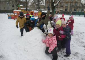 Dzieci pozują do zdjęcia na śniegu.