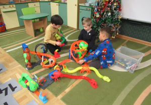 Chłopcy bawią się na dywanie.