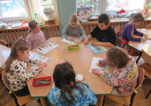 Dzieci rysują przy stoliku.