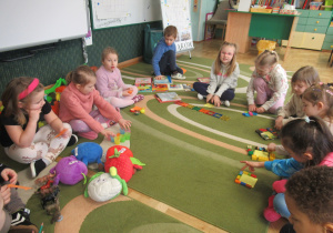 Dzieci siedzą w kole podczas zajęć matematycznych.