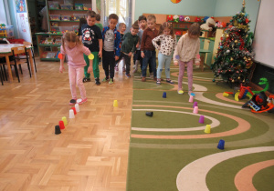 Dzieci podczas zabaw z kolorowymi kubeczkami.