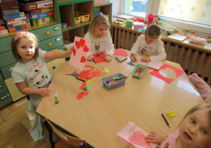 Dziewczynki rysują laurki dla innych dzieci.