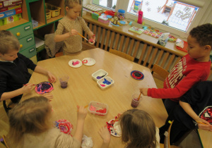 Dzieci malują farbami.