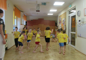 Dzieci biegają po sali podczas zajęć z elementami teakwondo.