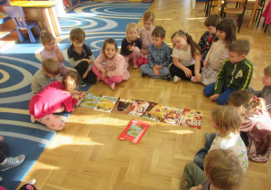 Dzieci siedzą w półkolu, układają historyjkę obrazkową.