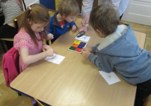 Chłopiec patrzy przez lupę.