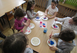 Dzieci malują farbami serca z masy solnej.