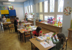 Dzieci przy stolikach podczas zajęć plastycznych.