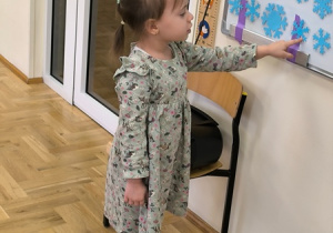 Dziewczynka przelicza papierowe śnieżynki