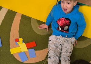 Chłopiec prezentuje robota ułożonego z klocków