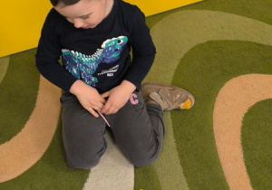 Chłopiec prezentuje robota ułożonego z klocków