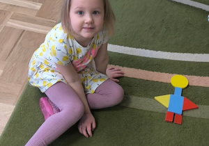 Dziewczynka prezentuje robota ułożonego z klocków