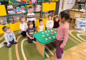 Dziewczynka przelicza pojemniki z ziarenkami