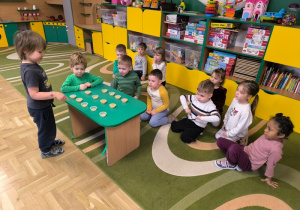 Chłopiec przelicza pojemniki z ziarenkami