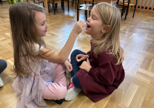 Dzieci łaskoczą się kawałkiem waty