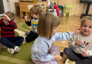 Dzieci łaskoczą się kawałkiem waty