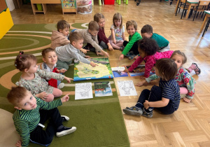 Dzieci wskazują obrazek przedstawiający Smoka Wawelskiego