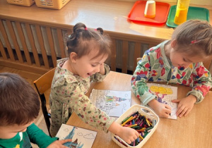 Dzieci kolorują obrazki przedstawiające najważniejsze miejsca w Krakowie