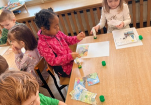 Dzieci przyklejają części obrazka
