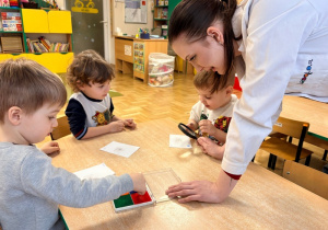 Dzieci odciskają swoje linie papilarne i oglądają je przez lupę
