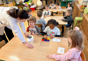 Dzieci odciskają swoje linie papilarne i oglądają je przez lupę