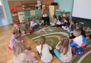 Dzieci siedzą w kole podczas zajęć języka angielskiego.