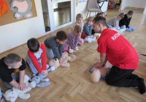 Dzieci udzielają pierwszej pomocy swoim przytulankom podczas warsztatów z pierwszej pomocy.