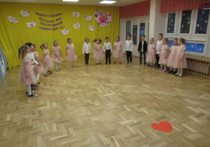 Dzieci stoją w półkolu podczas występu dla Babci i Dziadka.