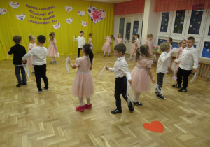 Dzieci tańczą w kole.