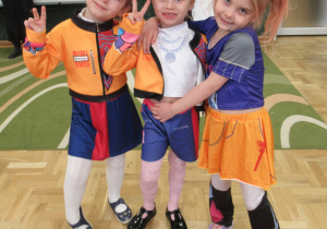 Trzy dziewczynki pozują do zdjęcia.