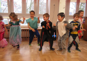 Dzieci tańczą na balu przebierańców.