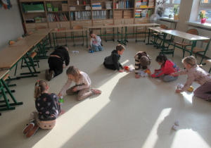 Dzieci bawią się robotami edukacyjnymi podczas zajęć w szkole.