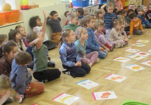 Dzieci siedzą na podłodze podczas zajęć matematycznych.