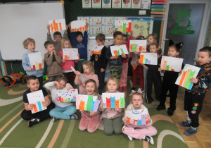 Dzieci prezentują swoje prace plastyczne - koty.