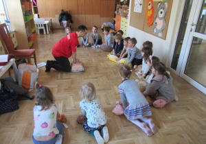 Dzieci ćwiczą udzielanie pierwszej pomocy swoim przytulankom.