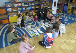 Dzieci siedzą w kole podczas zajęć z jężyka angielskiego.