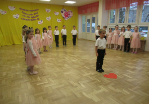 Dzieci stoją w półkolu podczas występu dla Babci i Dziadka.