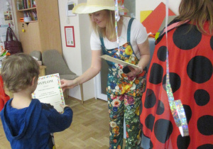 Chłopiec otrzymuje dyplom za udział w konkursie.