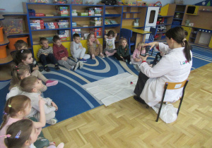 Dzieci siedzą w półkolu podczas warsztatów Labo.