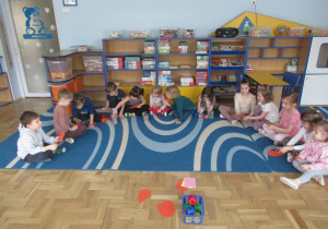 Dzieci siedzą w półkolu podczas zajęć matematycznych.