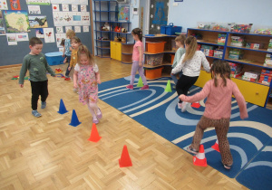 Dzieci biegają między pachołkami, w rączkach trzymają serwetki papierowe.